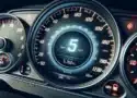 Tableau de bord avec odomètre : Une image montrant un close-up du tableau de bord d'une voiture, en mettant l'accent sur l'odomètre, pour symboliser le suivi des kilomètres.